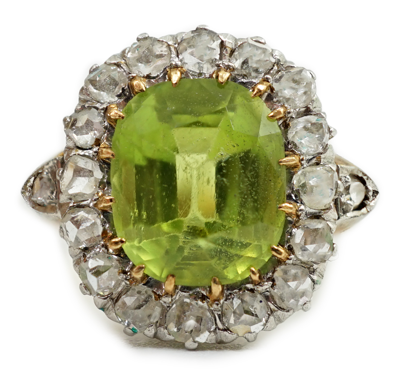 An early 20th century gold, peridot and diamond set oval cluster ring